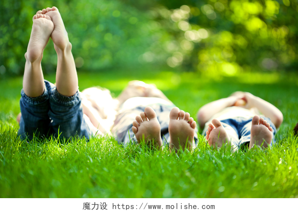 春天公园里躺在草地上休息的孩子躺在绿草地上的快乐儿童